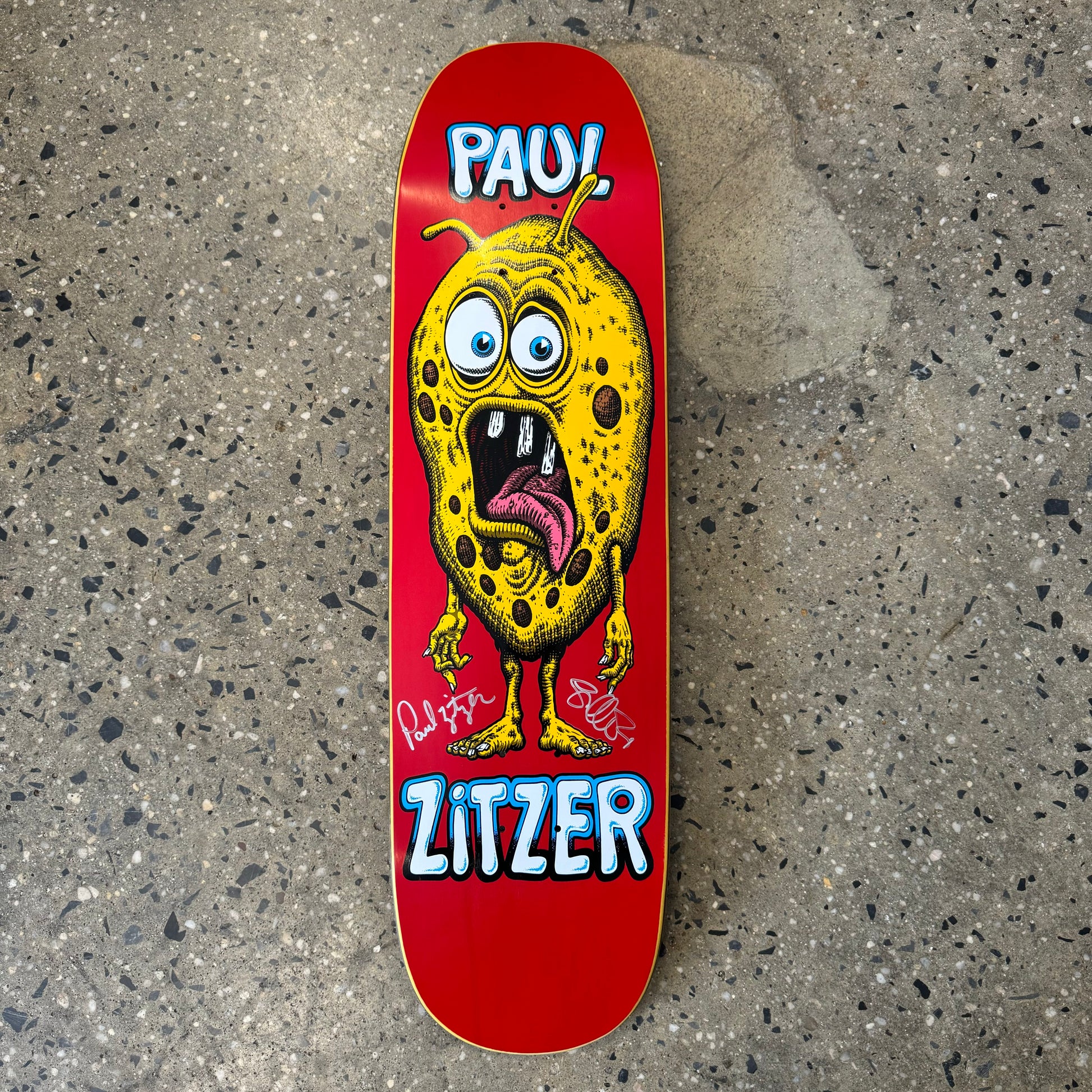 red skateboard deck with yellow monster on it