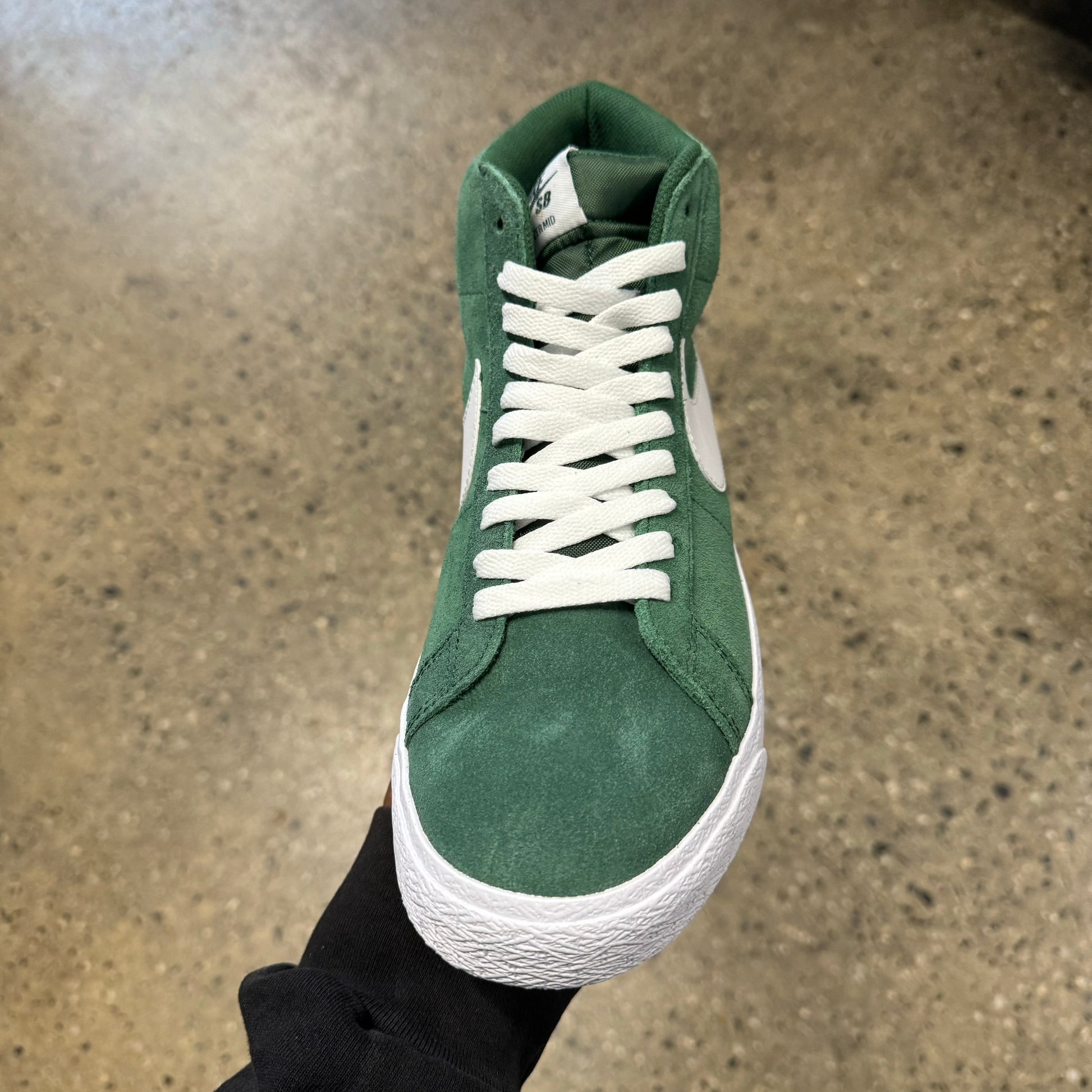 top down view of green suede sneaker with white laces and white sole
