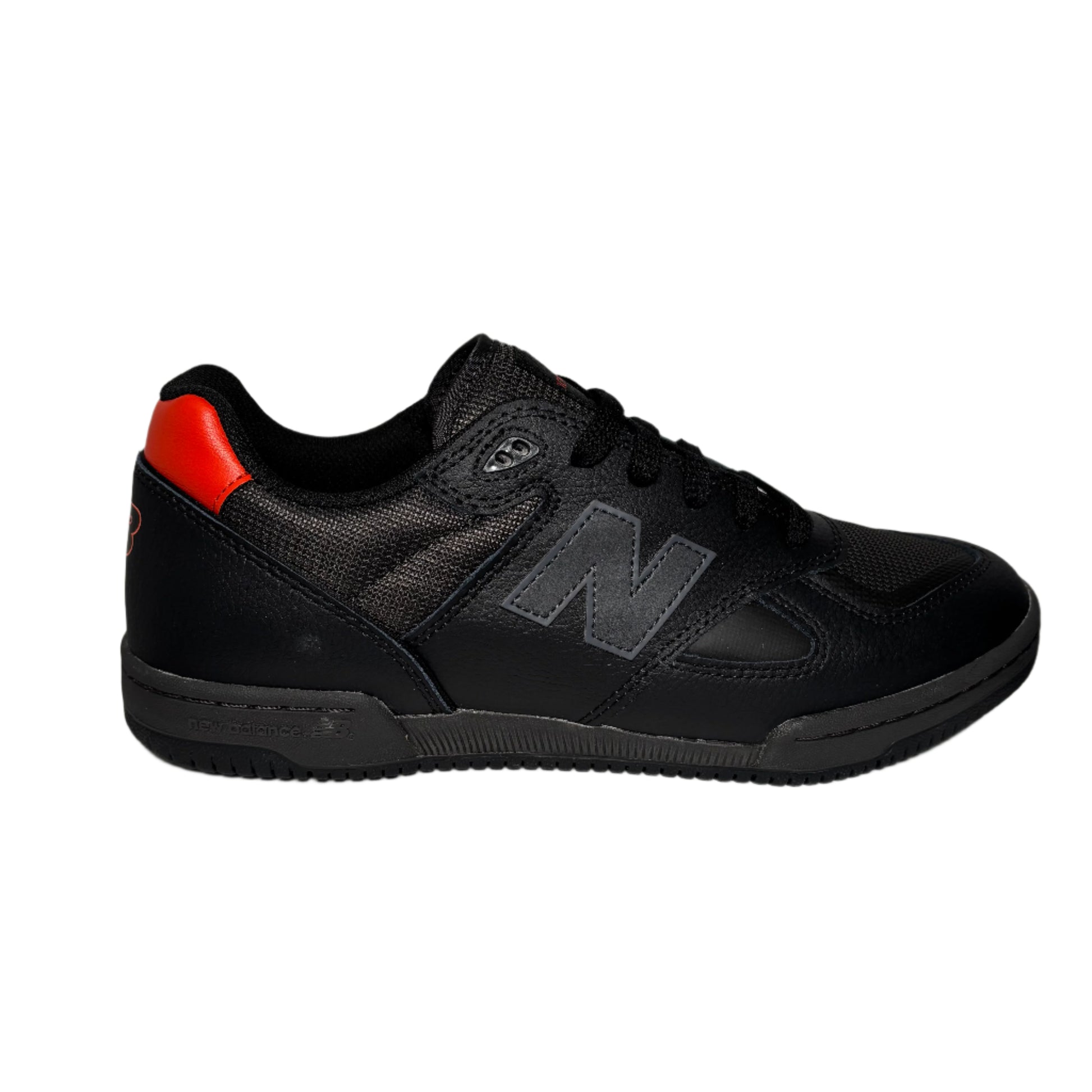 Black sneaker with a red heel on a gray background