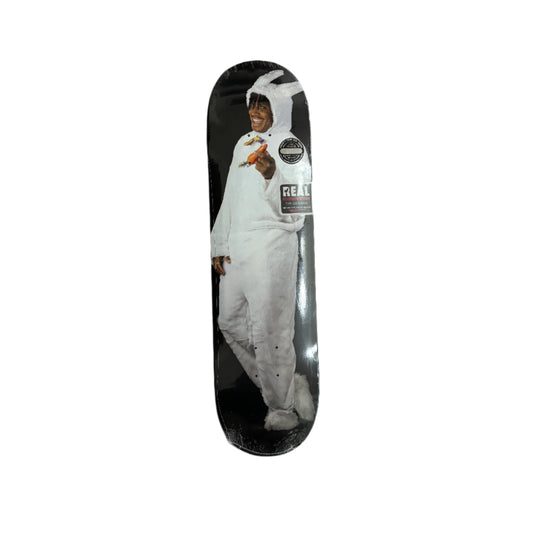 Skateboard deck with a graphic of a person in a white suit against a black background, on a white surface