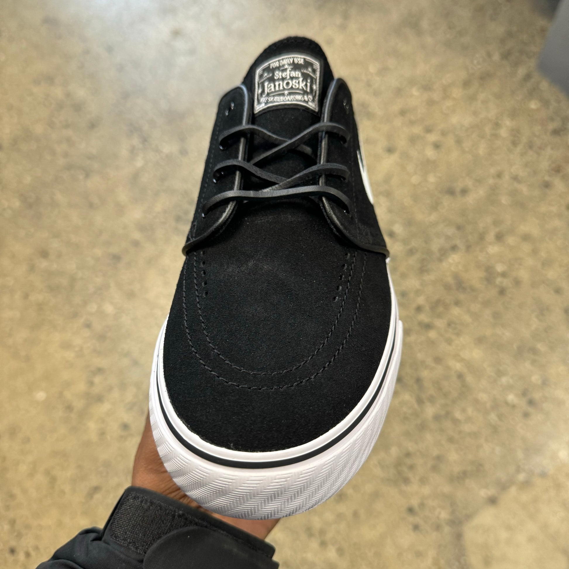 top down view of black sueded low top sneaker, suede laces, white sole
