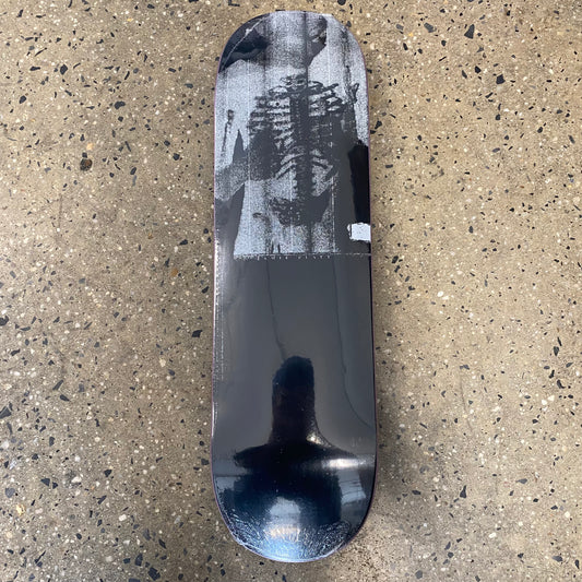 black skateboard with a grey photo of a man and skeleton