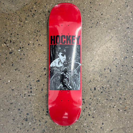 red skateboard deck with black and white ominous art in the center