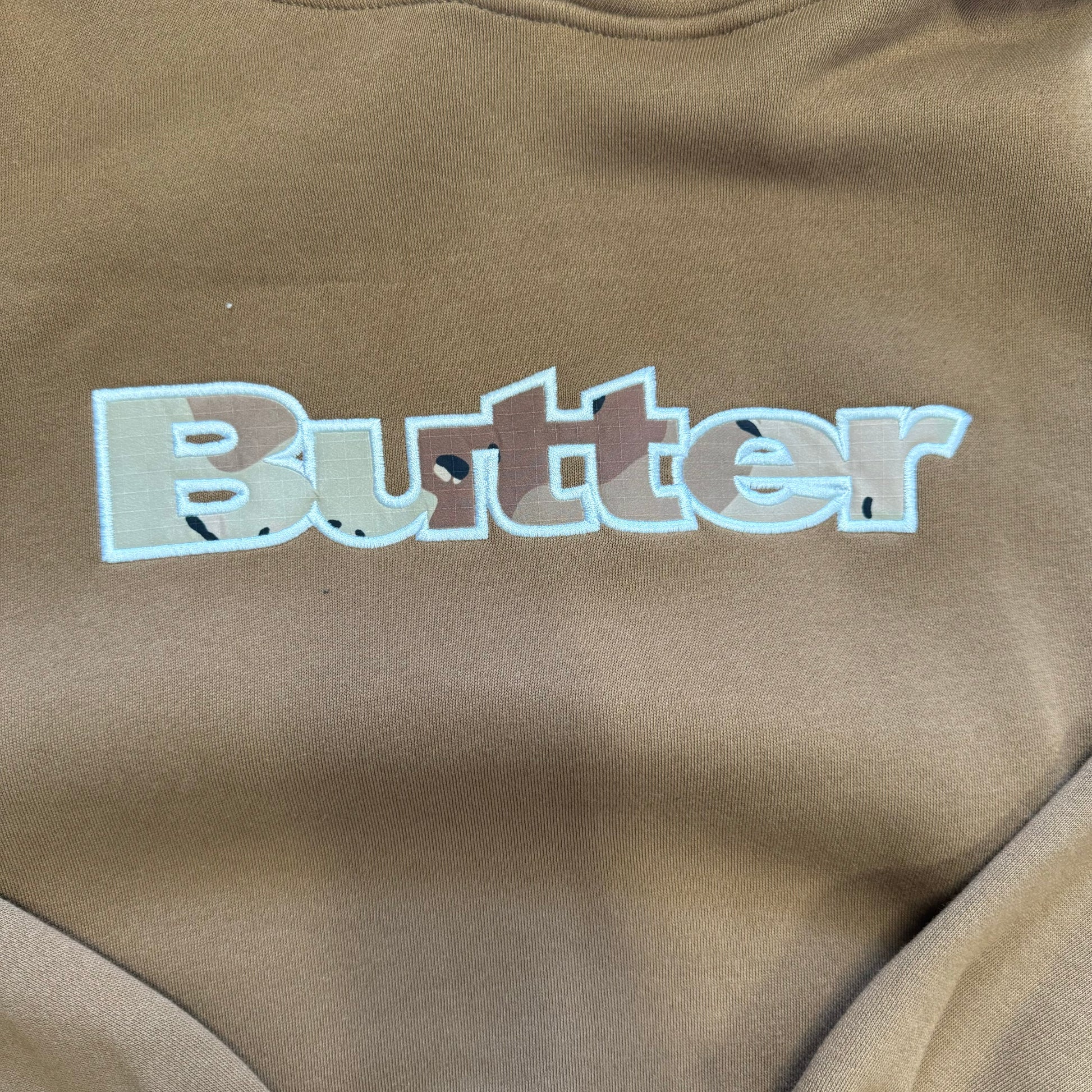 close up view of embroidered BUTTER logo