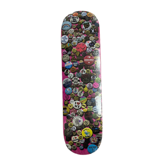 Skateboard deck with colorful assorted pins on a white background