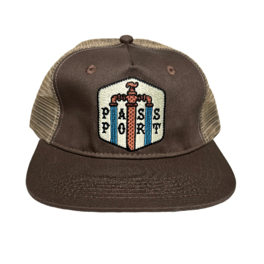 Brown cap with a decorative patch on a white surface