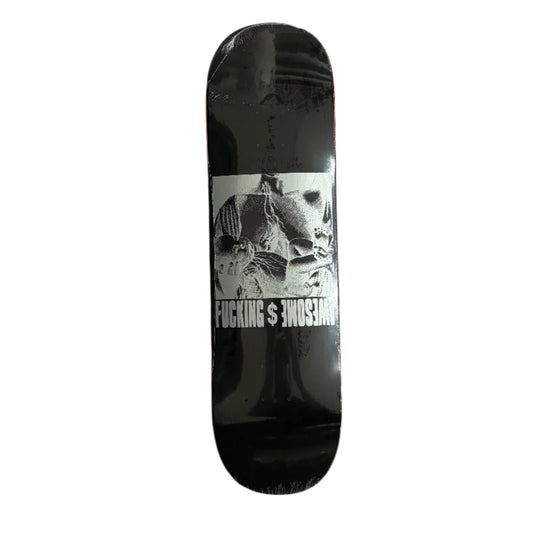 Black skateboard deck with graphic design and text on a gray surface