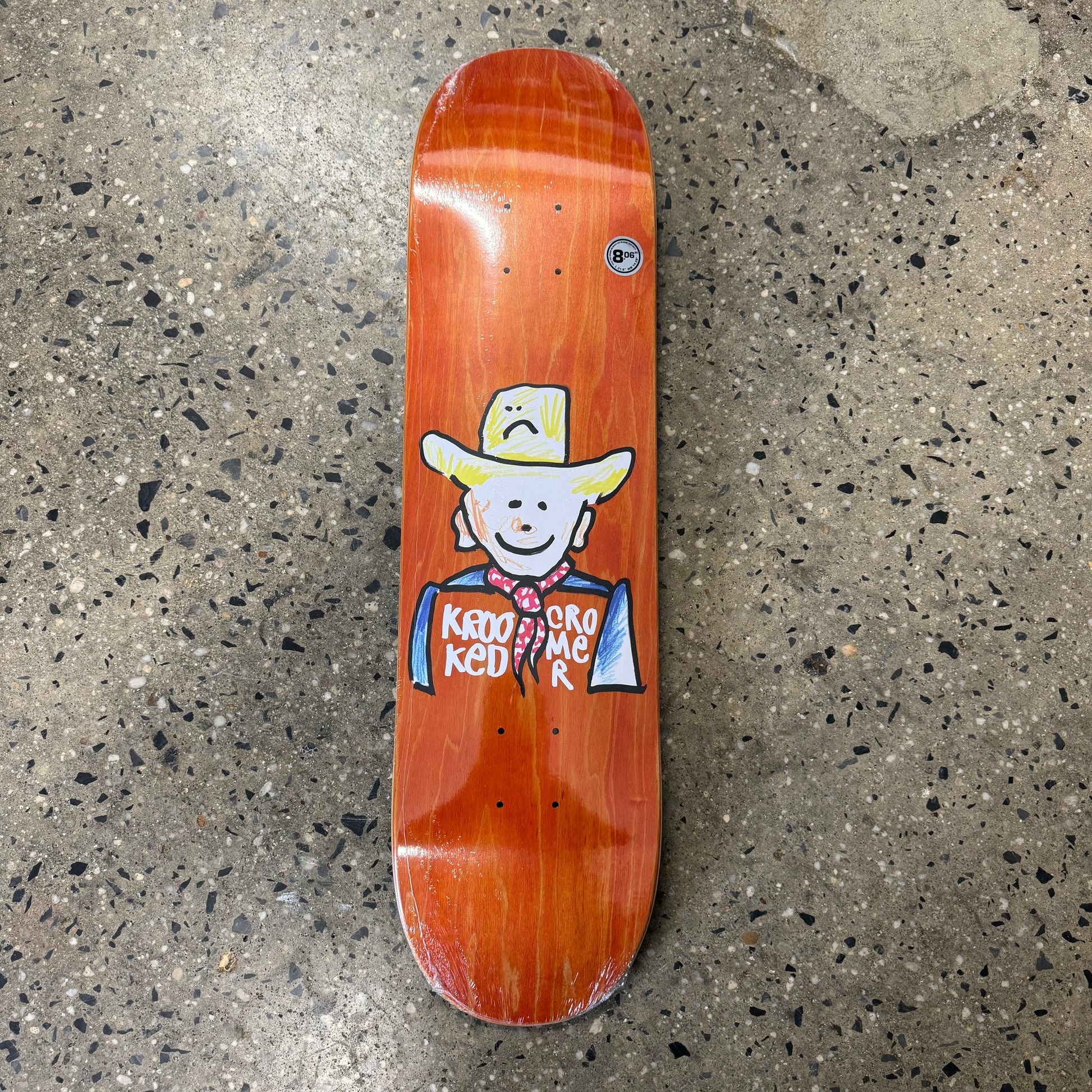 drawing of cowboy on orange wood grain skate deck (wood grain colors may vary)