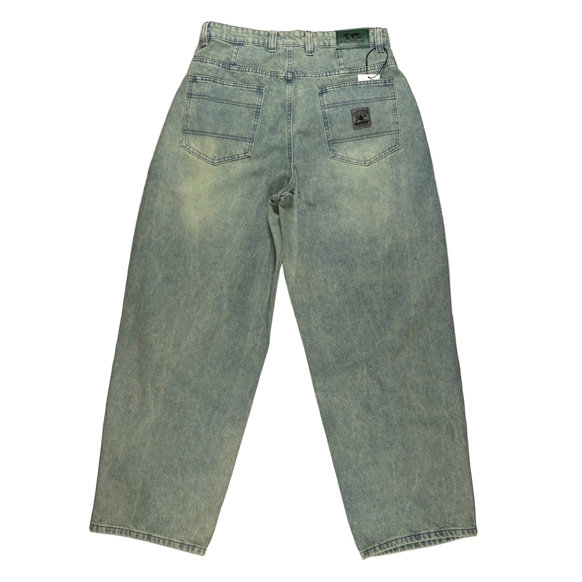 rear view of blue/Green jeans laid flat on a white surface