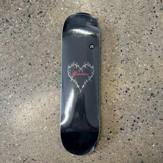 black skateboard deck with a silver heart with red text in the center