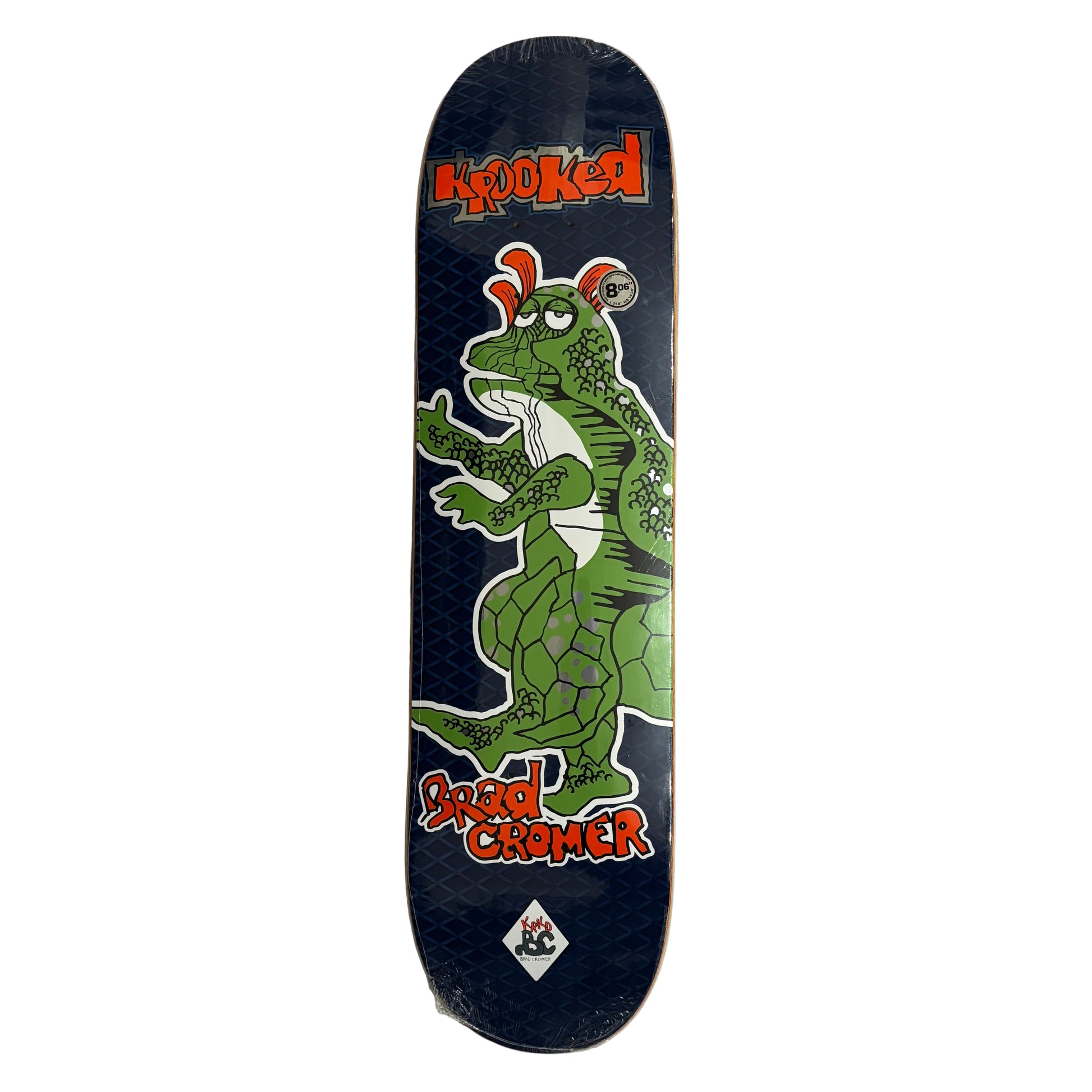 Skateboard deck with a green dragon design and krooked branding on a white surface