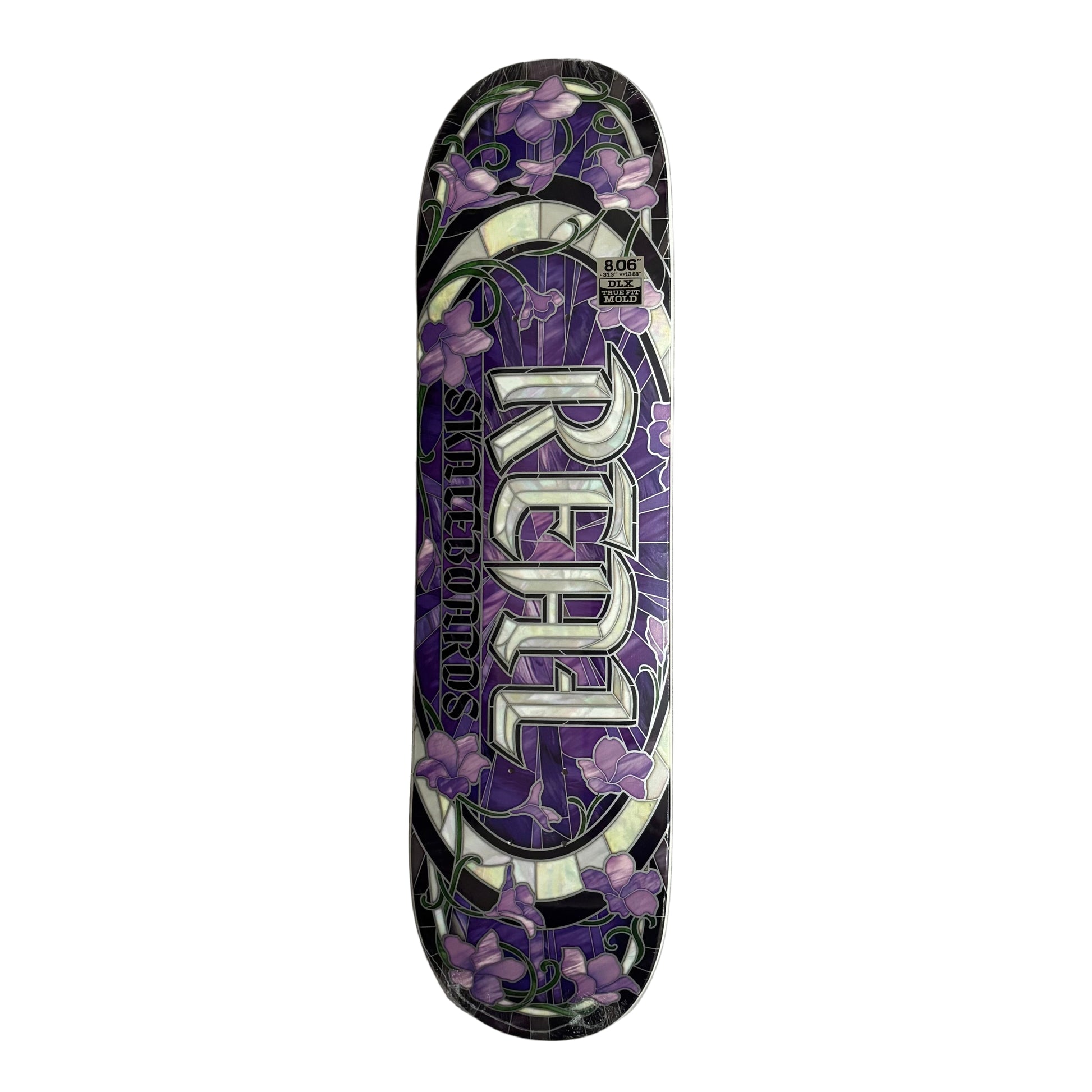 Skateboard deck with purple floral design and 'Real' branding on a white surface.