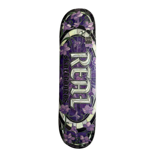 Skateboard deck with purple floral design and 'Real' branding on a white surface.