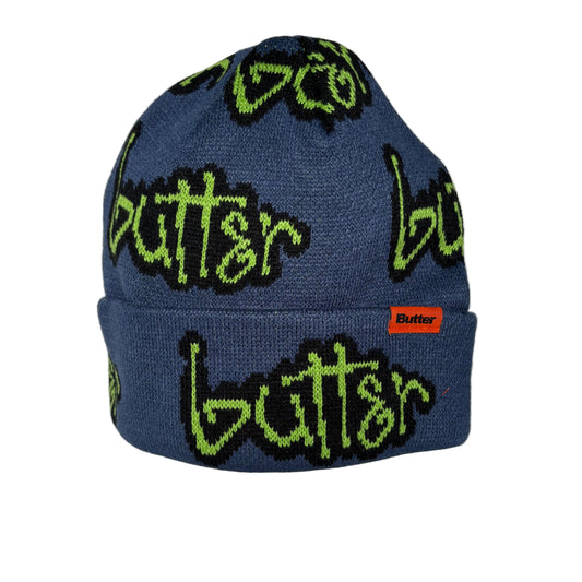 Blue beanie with green and black BUTTER branding, on a white background