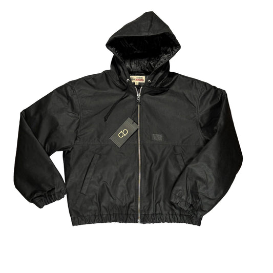 Black waxed work jacket with a brand tag on a white surface