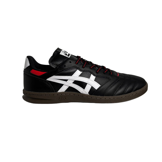 Black and white sneaker with red accents on a white pedestal against a white background