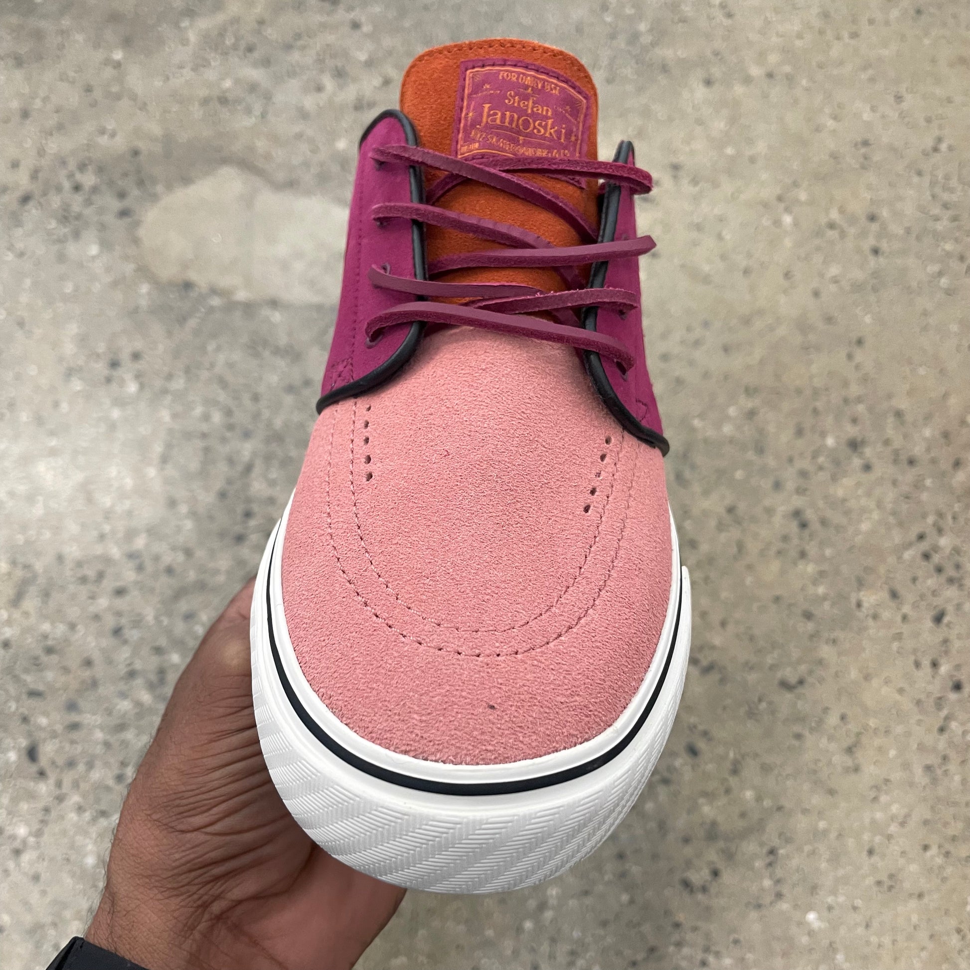 top down view of dual tone pink suede sneaker, laces, and shoe toe box