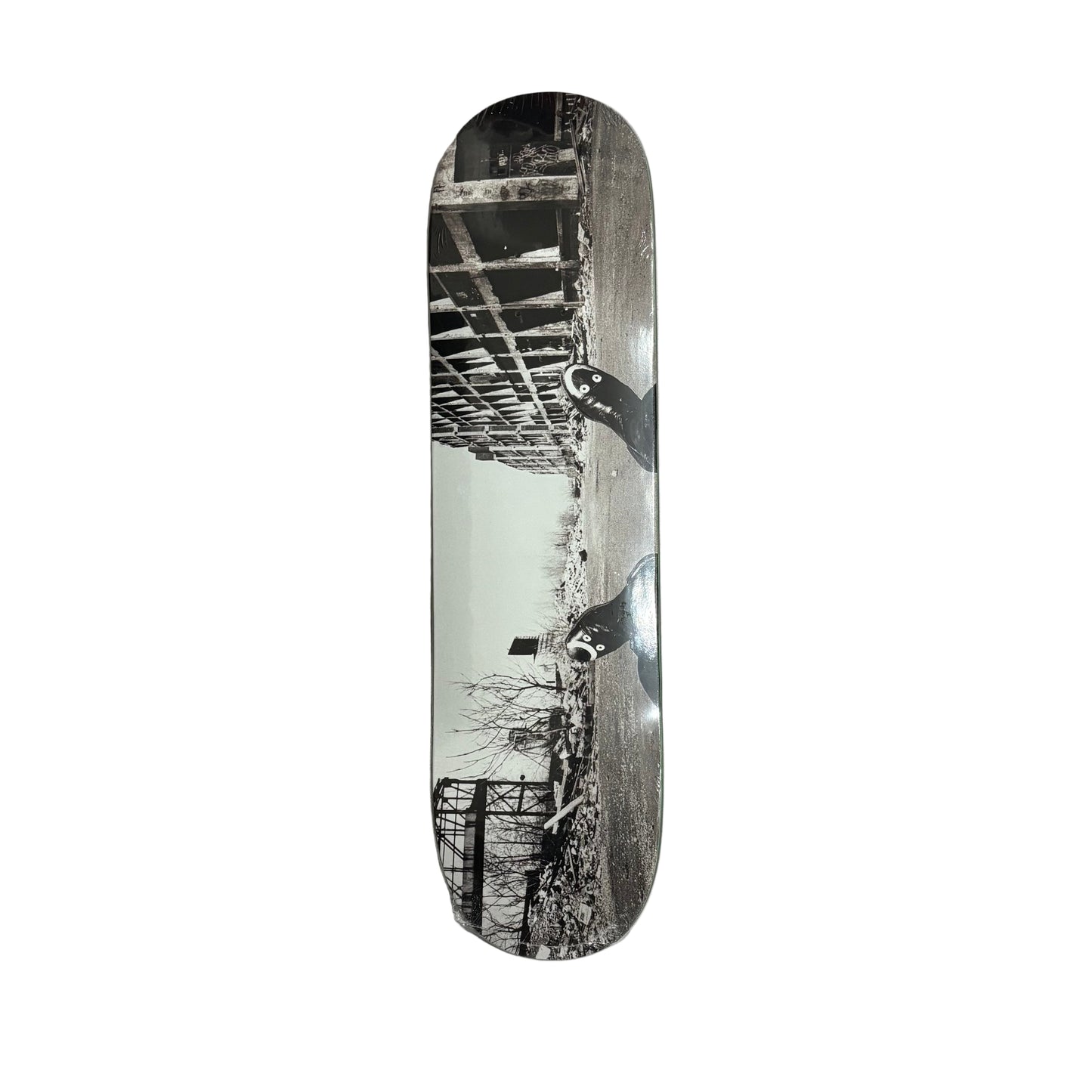 Skateboard deck showing a building, bridge and trees on a white background