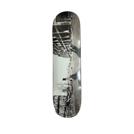 Skateboard deck showing a building, bridge and trees on a white background