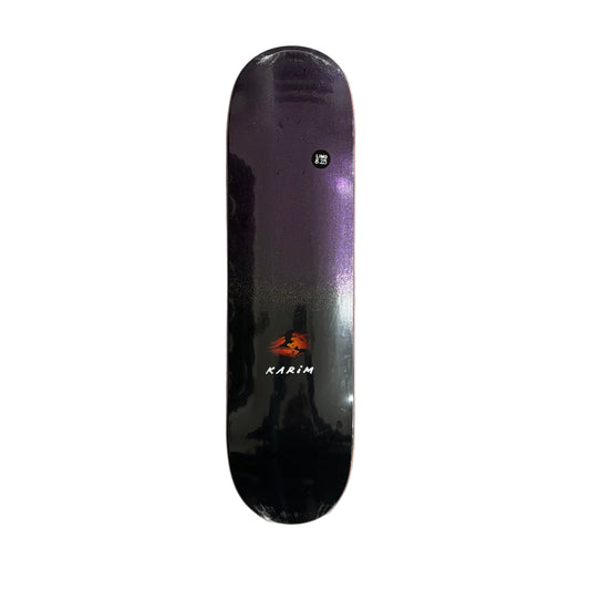 Black and purple glitter skateboard deck with branding on a white surface