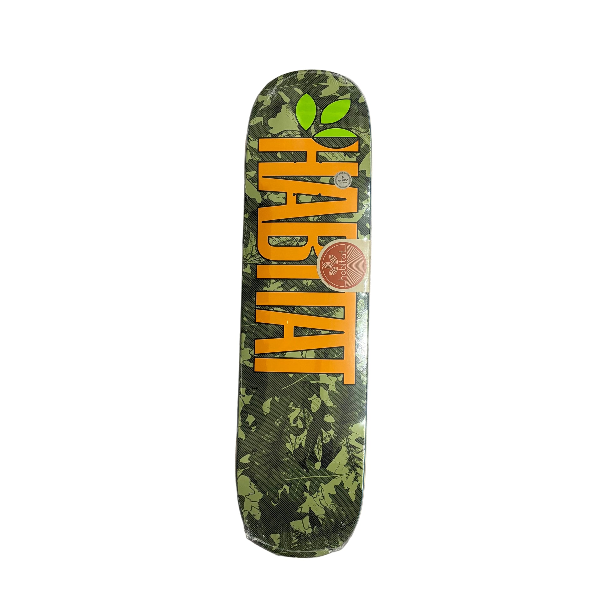 Skateboard deck with green leaf pattern and orange text on a white surface