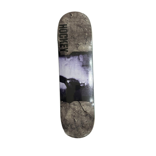 Skateboard deck with a black and white graphic design on a white surface