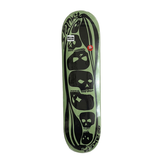 Skateboard deck with black skull designs on a light green background, placed on a white surface.