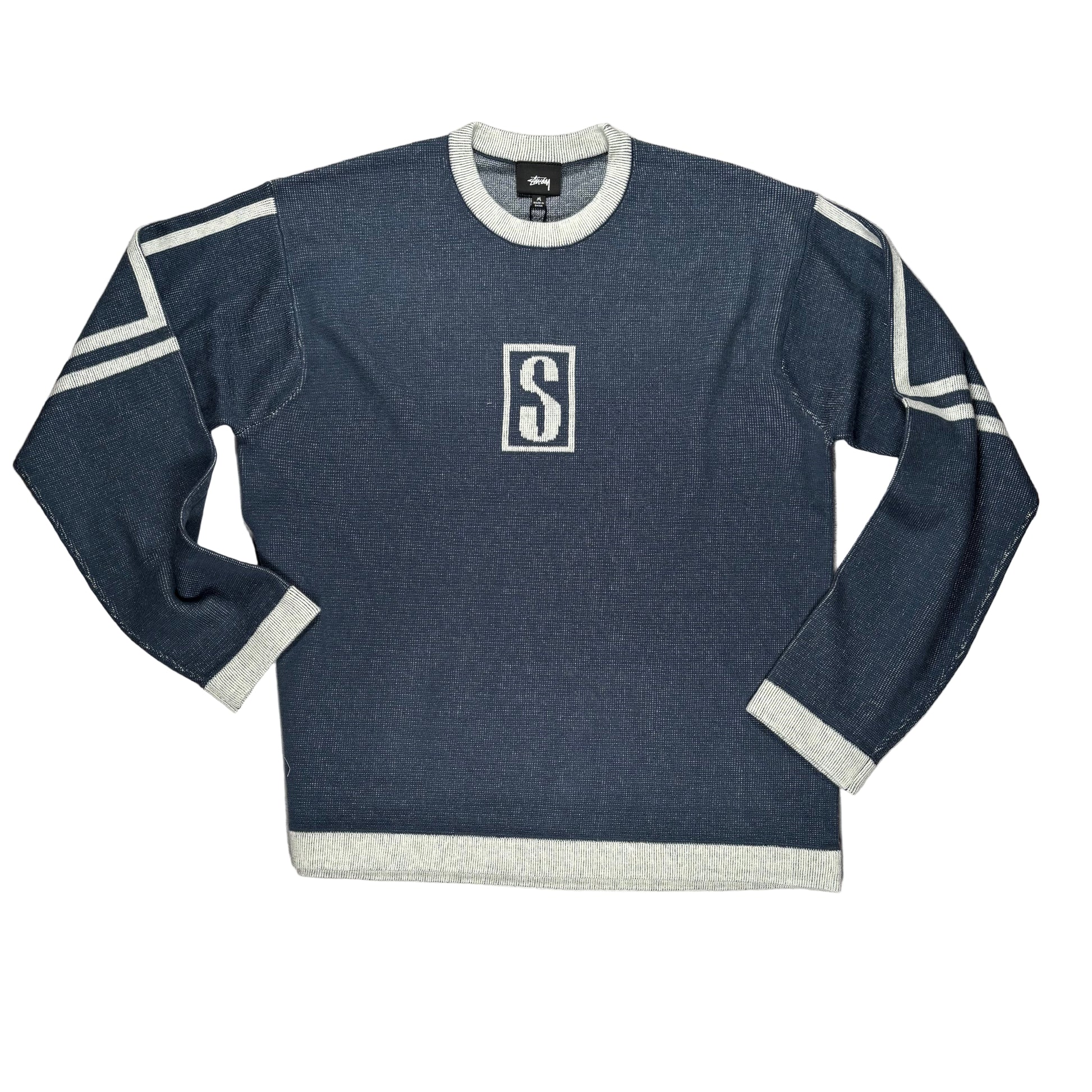 Blue sweater with a logo on a white surface