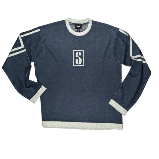 Blue sweater with a logo on a white surface