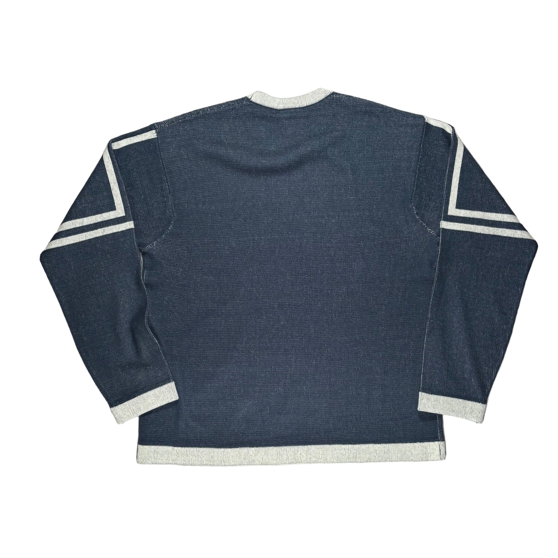 Blue long-sleeve sweater with white trim on a white surface