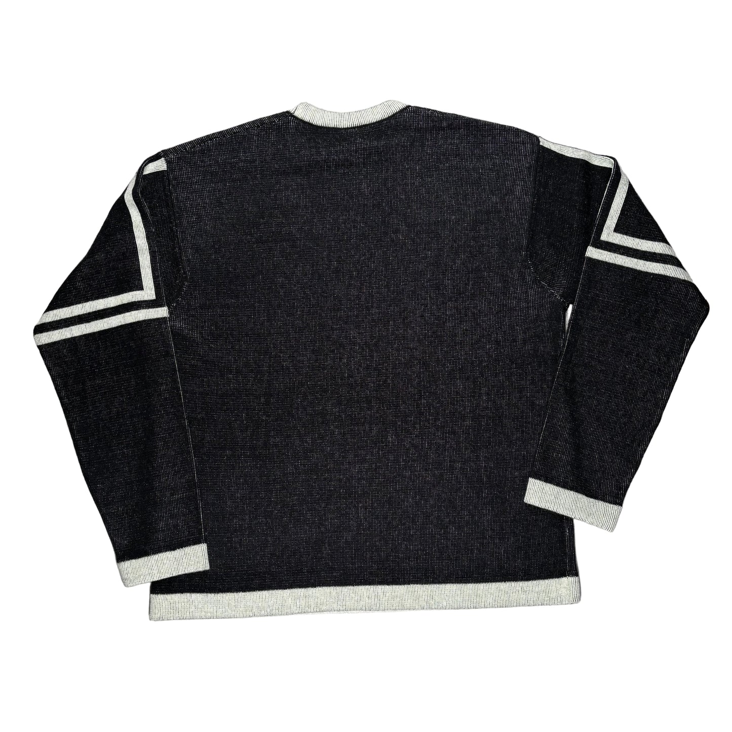 Black sweater with white trim on a white surface