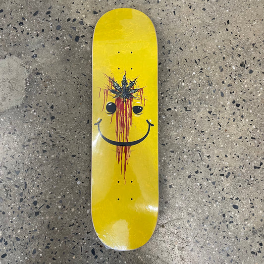 smily face with marijuana leaf and blood on yellow skate deck