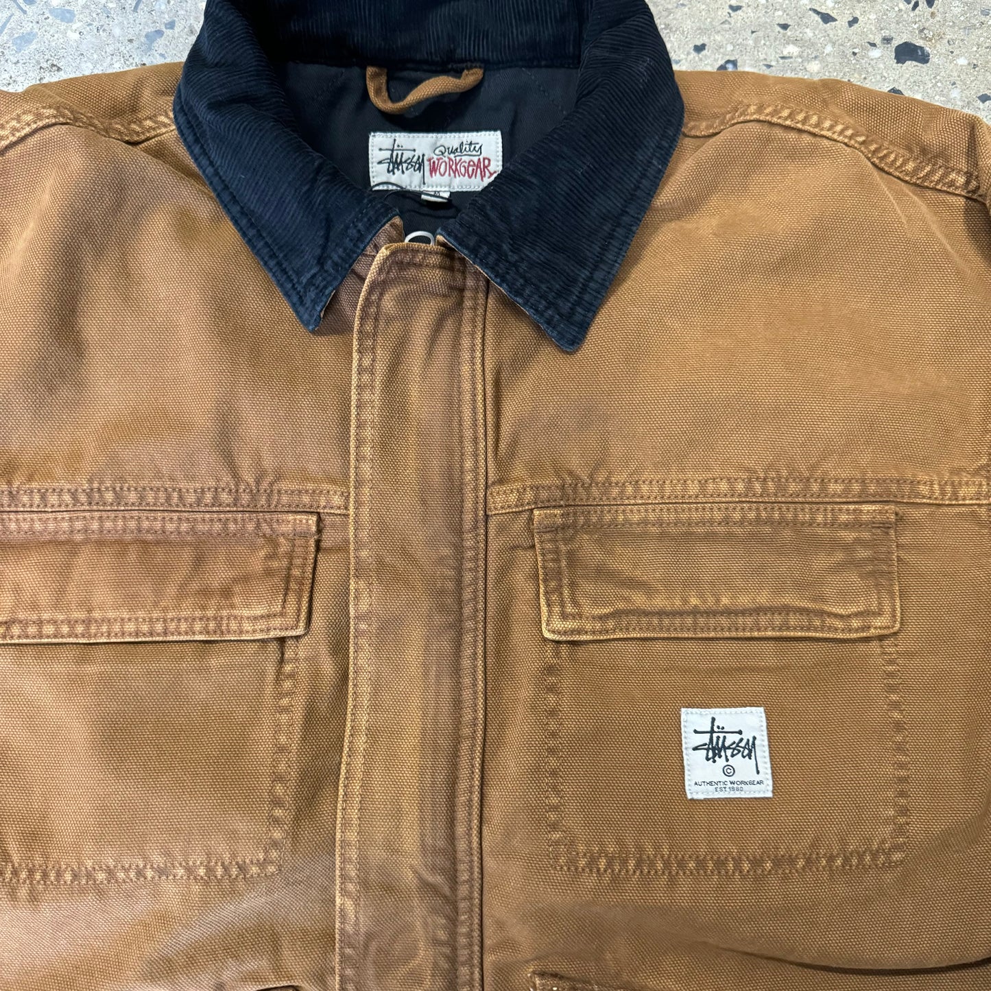 close view of black corduroy collar on brown canvas jacket