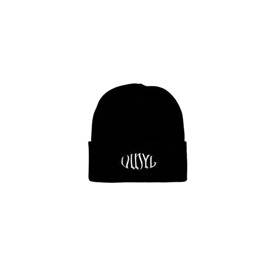 Black beanie with white text on a white surface