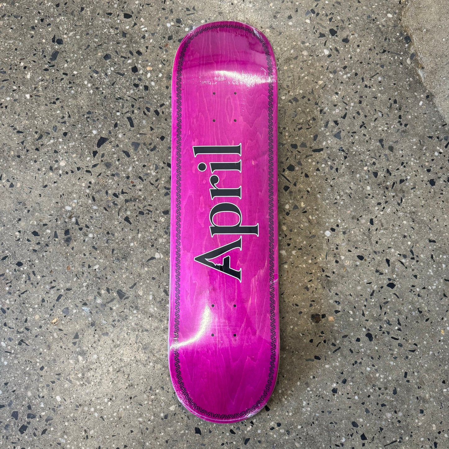 black April logo on pink skate deck