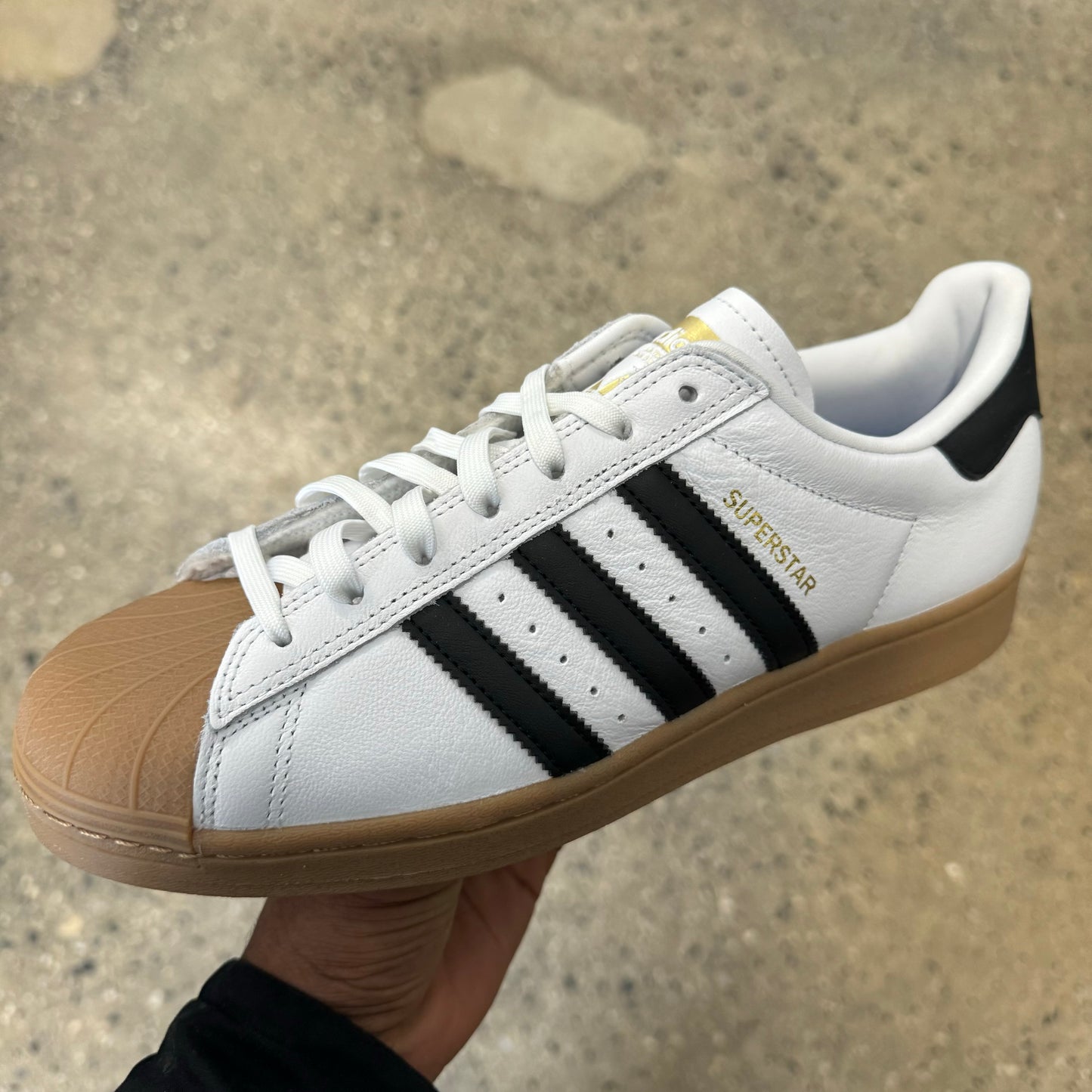 white leather sneaker with black stripes, gum toe and sole, side view