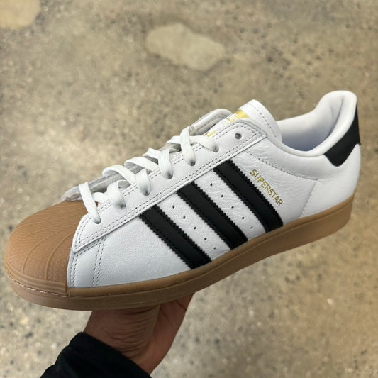 white leather sneaker with black stripes, gum toe and sole