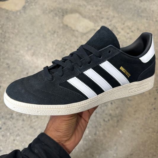 black suede sneaker with white stripes and white sole