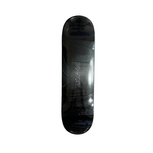 Black skateboard deck with a brand logo on a white surface