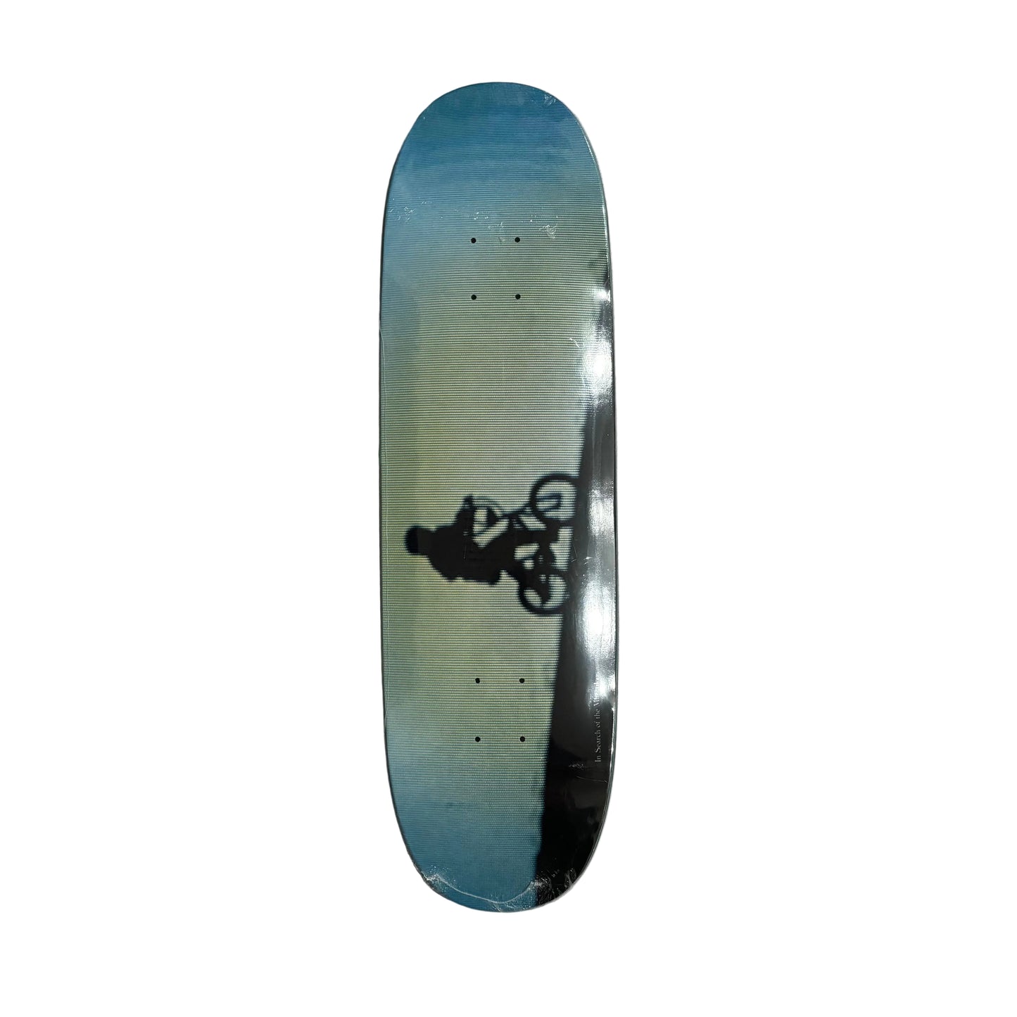 Skateboard deck with a graphic of a person on a bike on a white surface.