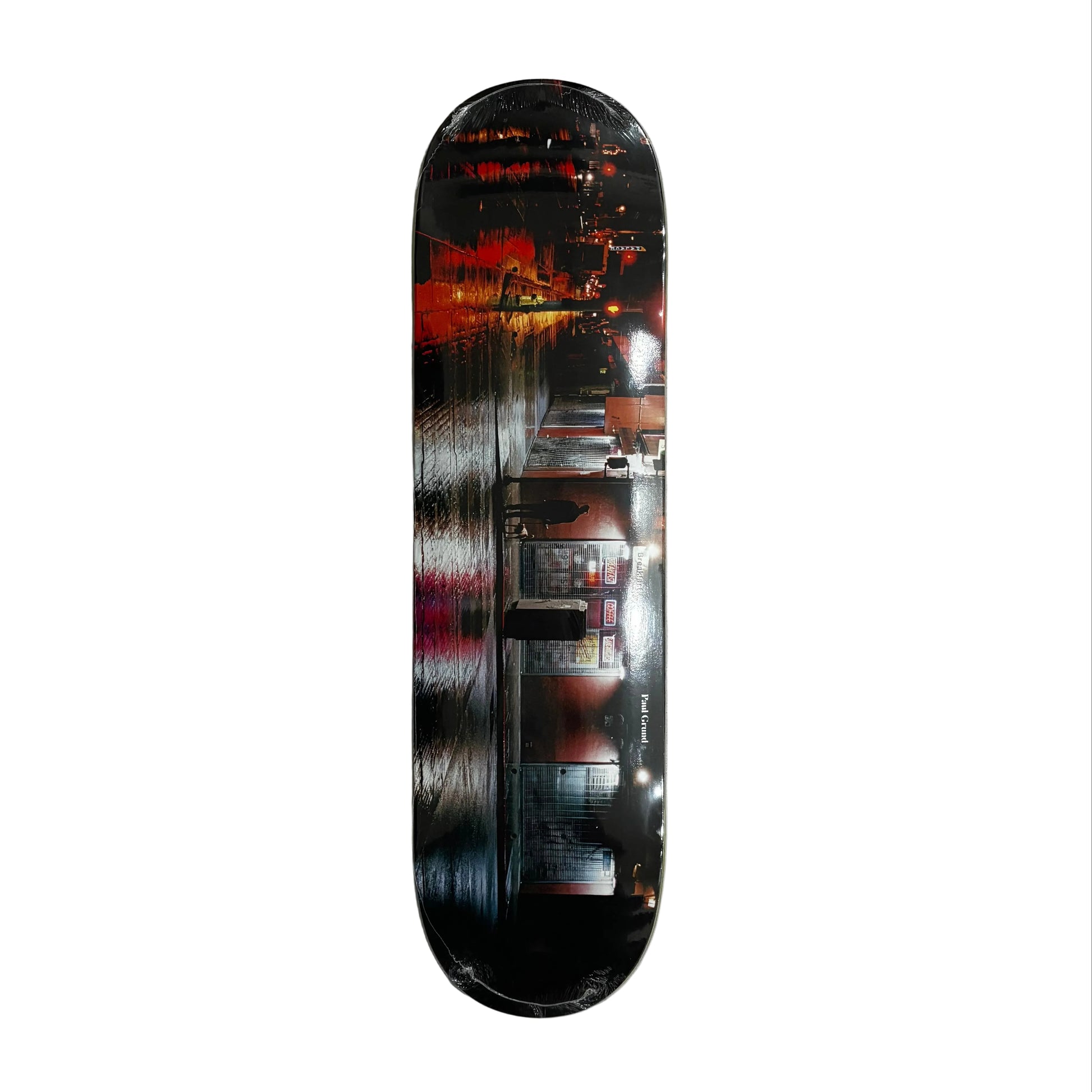 Skateboard deck showing a cityscape at night on a white background