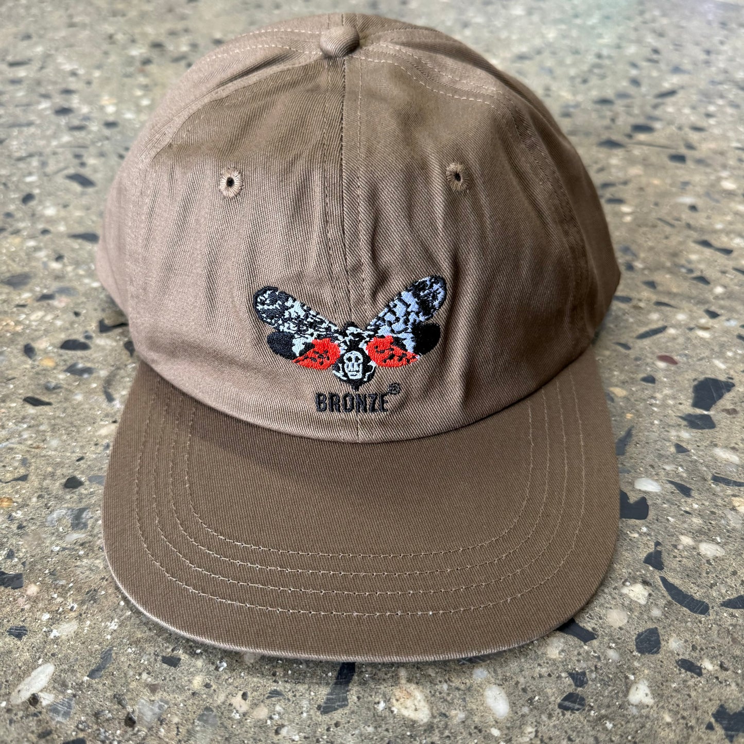 khaki hat with multi color butterfly logo