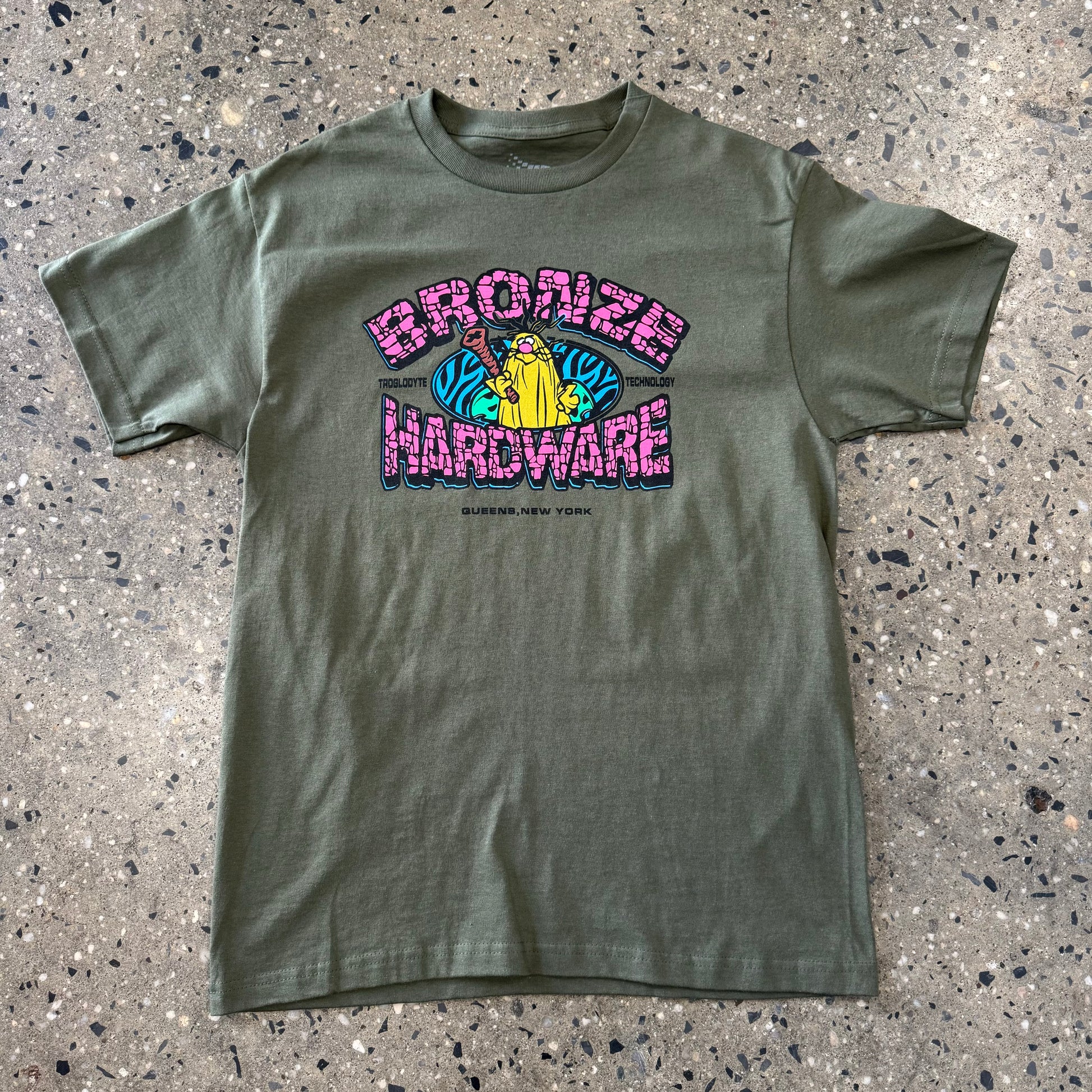 pink, blue, and yellow caveman on military green T-shirt