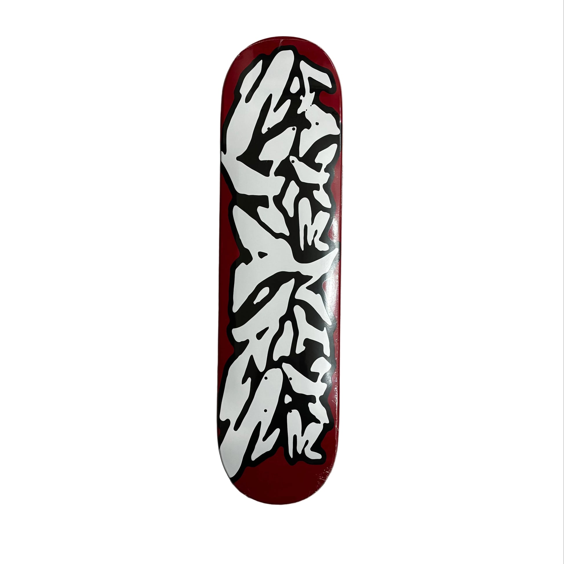 Skateboard deck with white graphic design on a red background, placed on a white surface.