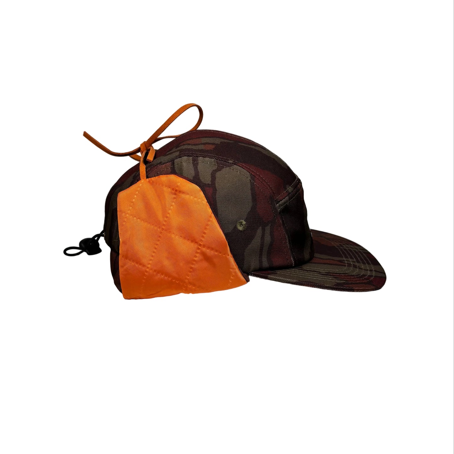 Brown and orange earflap cap on a white pedestal background