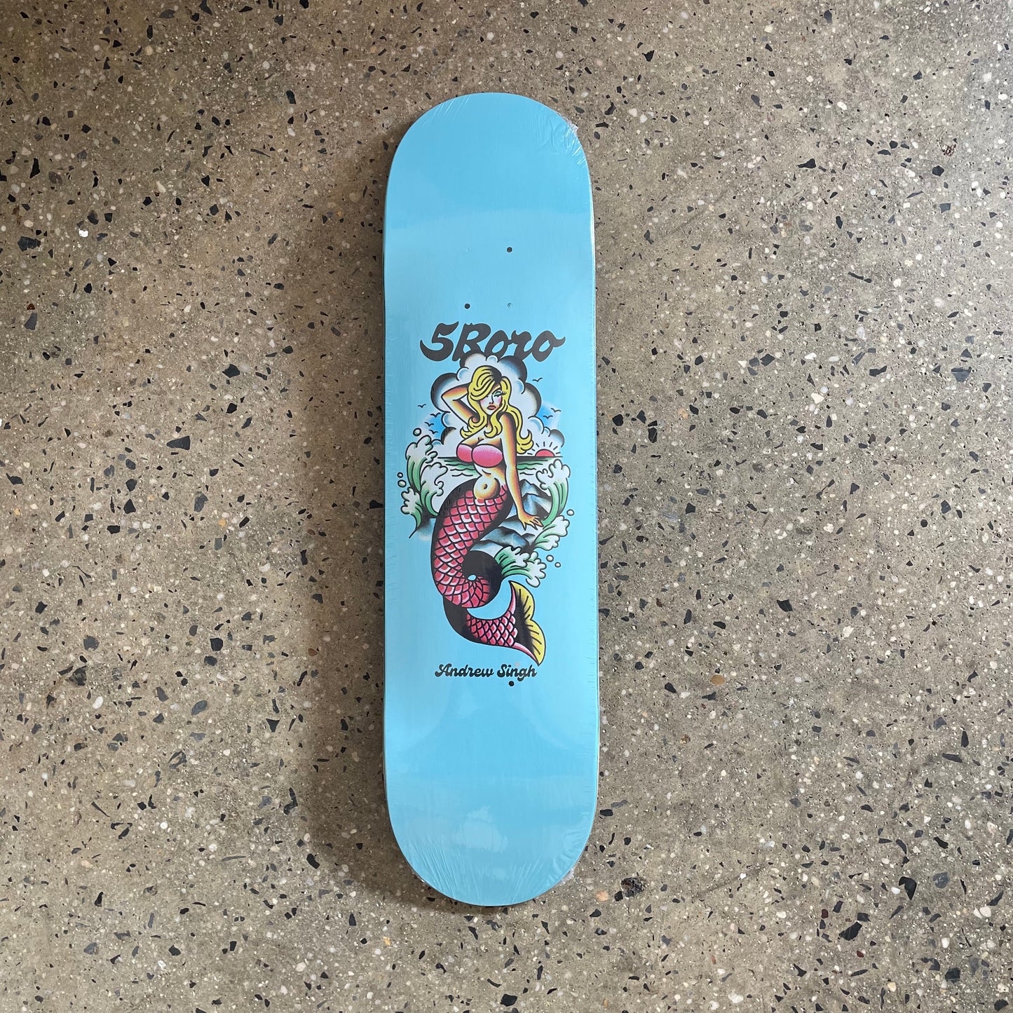 Blue skate deck with classic tattoo art style mermaid on the bottom