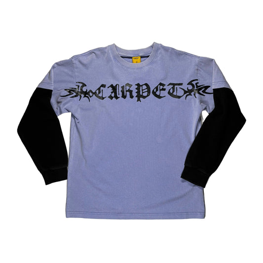 Purple and black long-sleeve shirt with black text on a gray surface