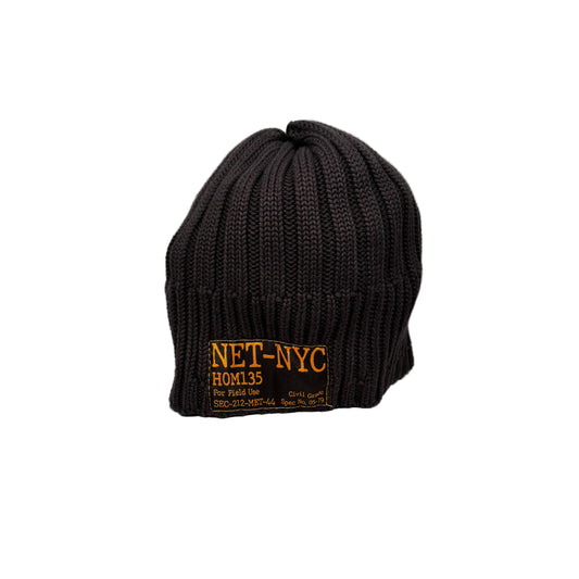 Black knit beanie with gold text on a woven label, on a white background