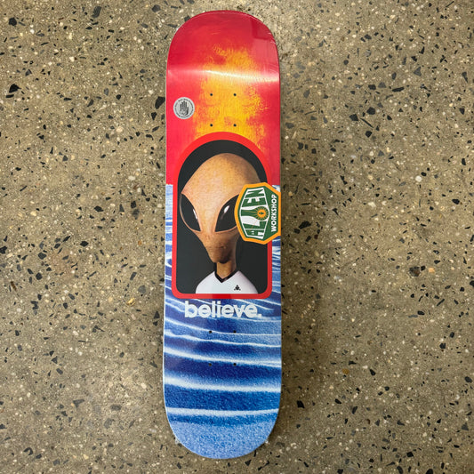 large alien head with multicolor sun and sand background, believe written underneath on skate deck