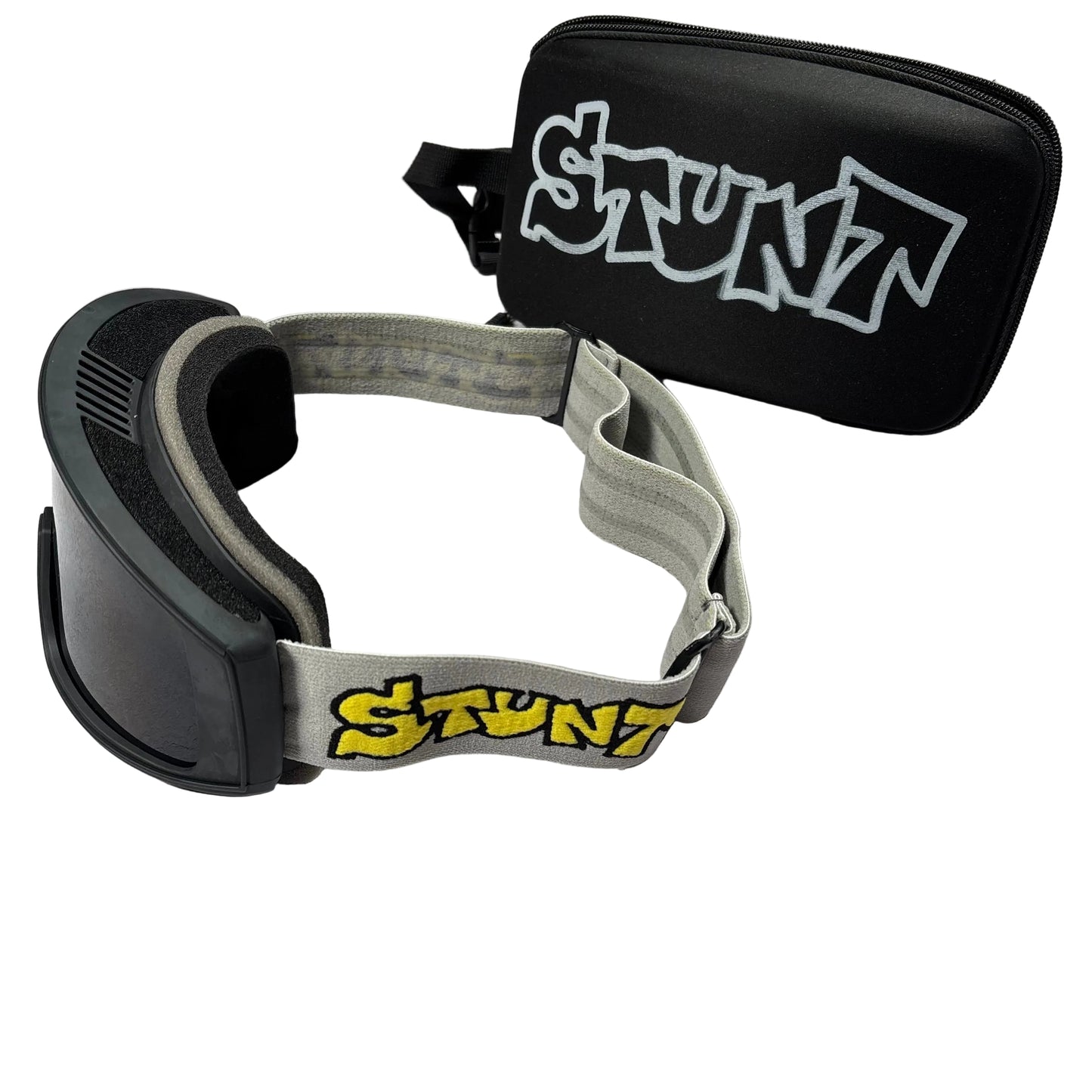 Goggles with gray strap and black frame, accompanied by a black case with 'Stunt' branding on a light gray surface.